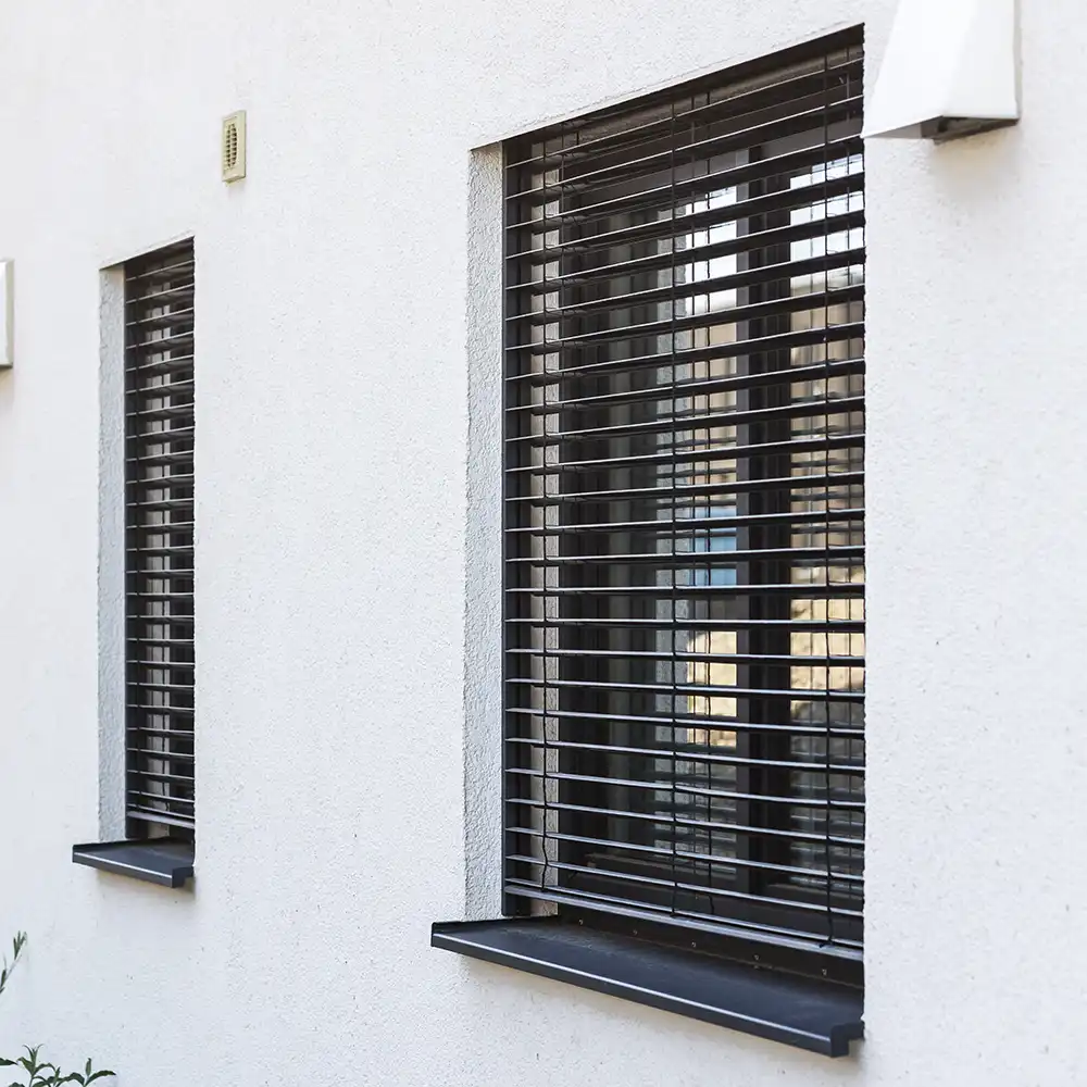 Rollos an modernen Fenstern im Außenbereich. Außenjalousien an Fenstern. Fenster Rollos Außen.